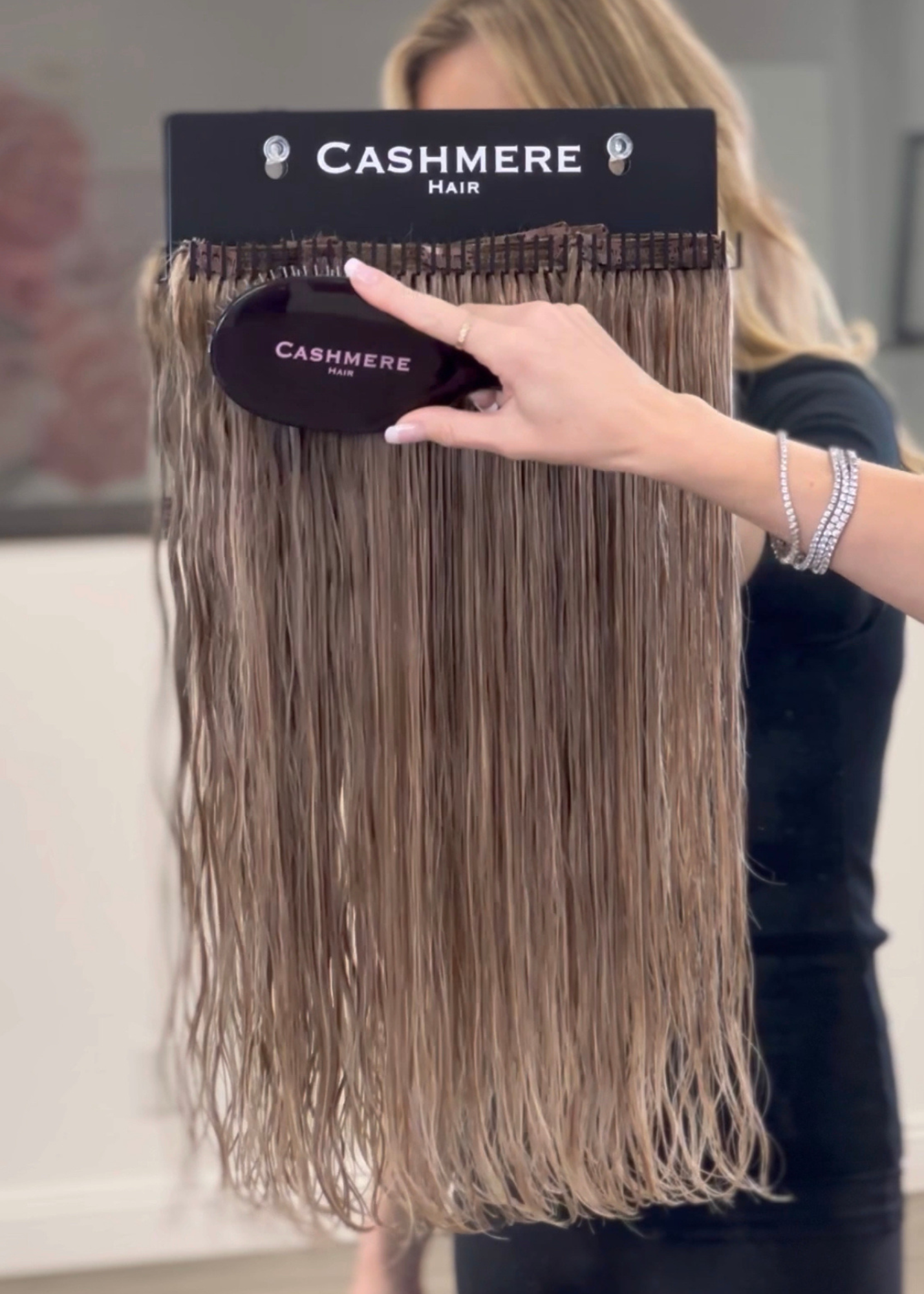 detangling a set of cashmere hair extensions with the cashmere hair extension brush