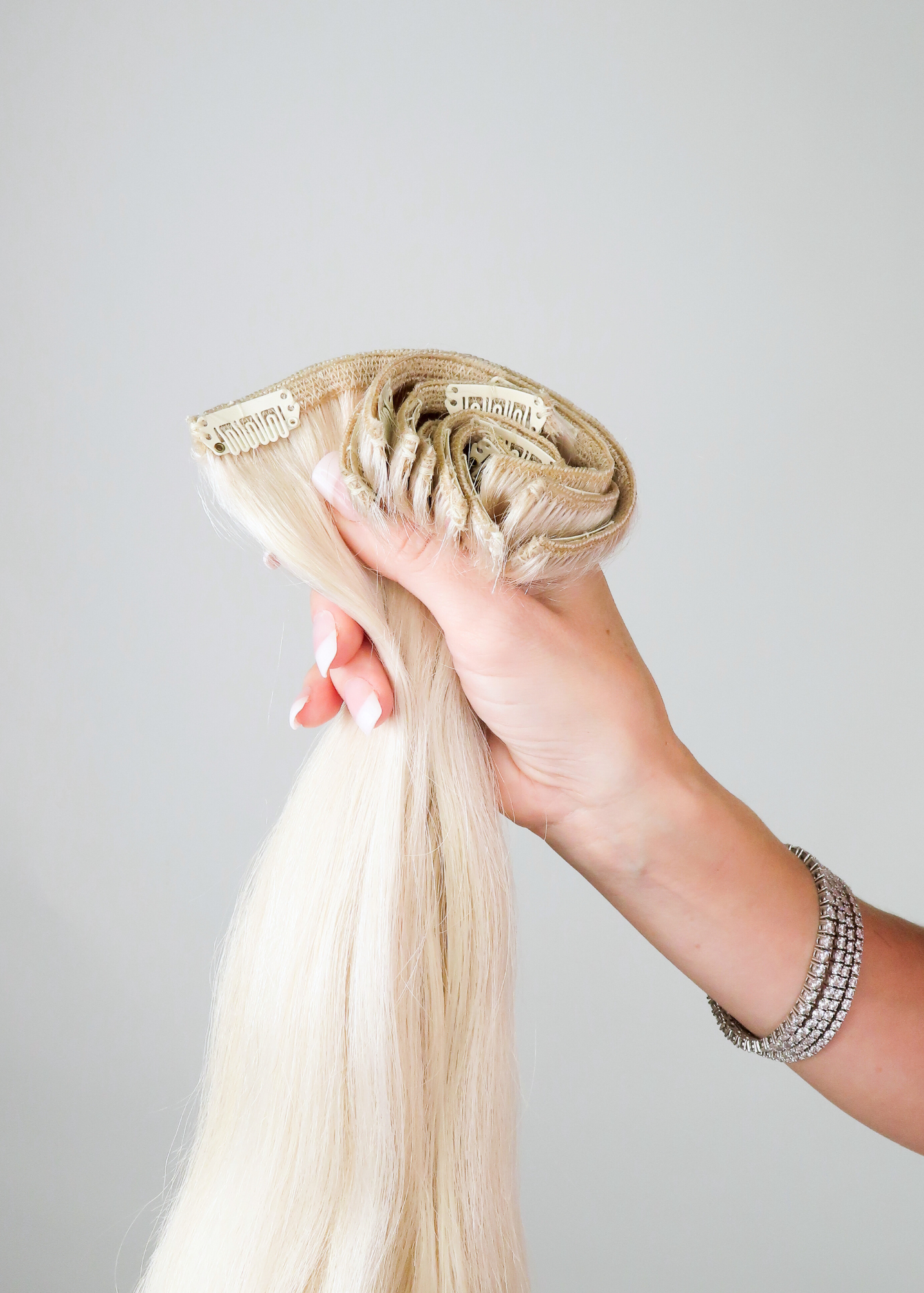 woman holding a full set of cashmere hair classic clip-in extensions