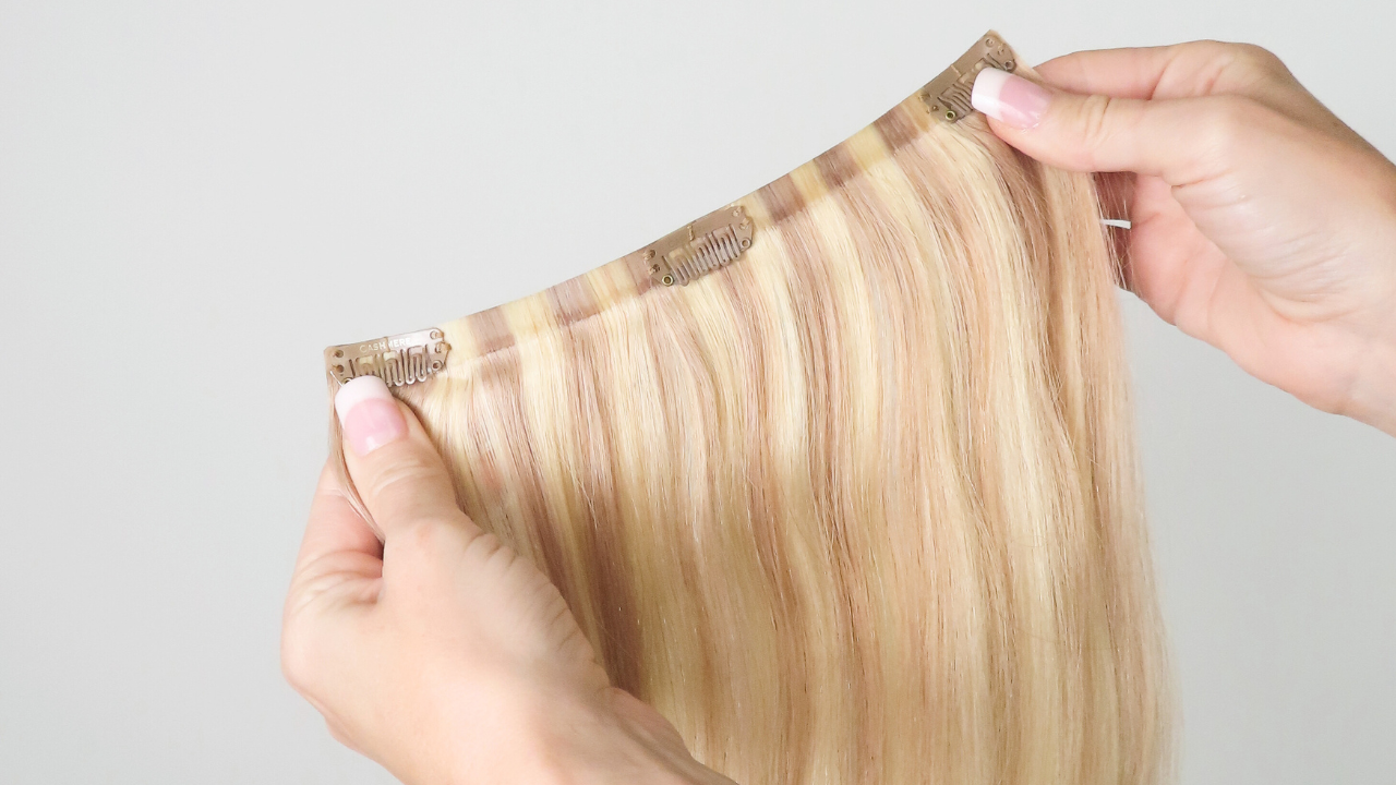 person holding one track of seamless clip-in extensions from Cashmere Hair