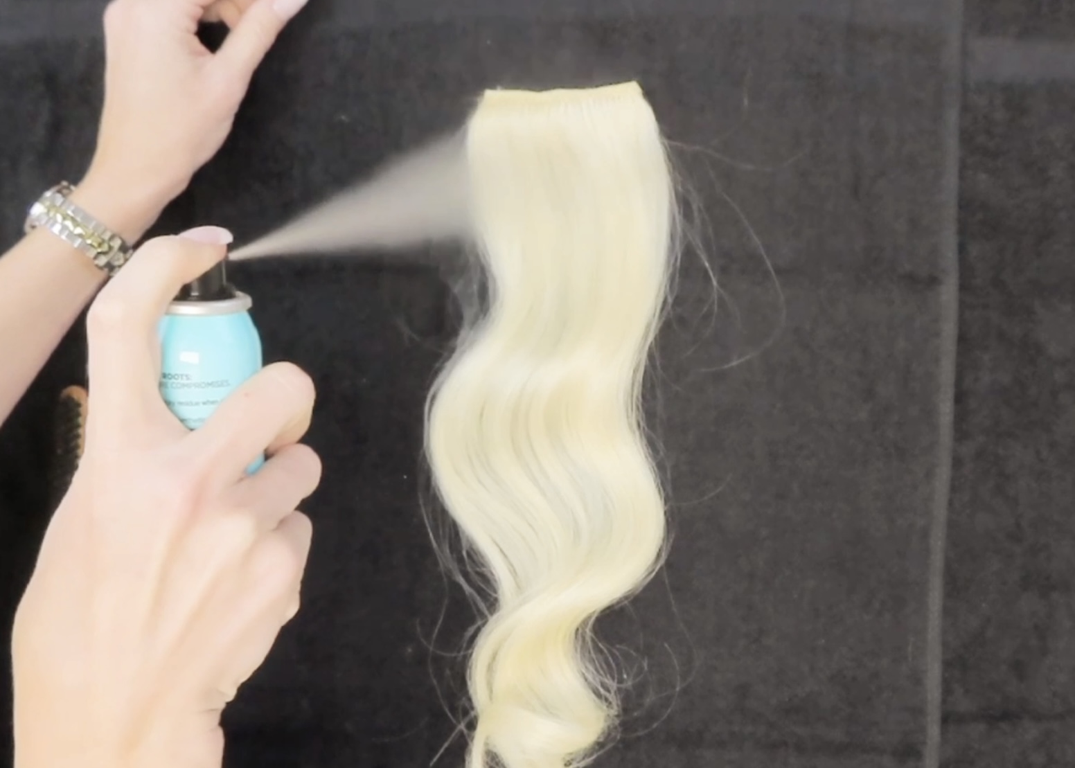 spraying root spray on Cashmere Hair extensions