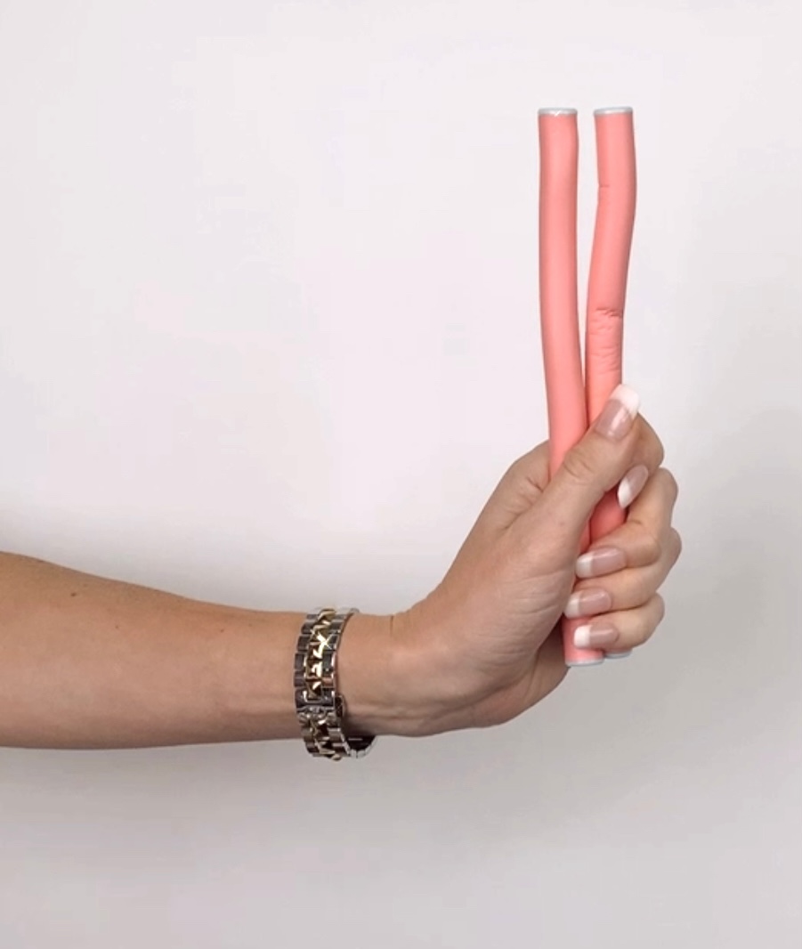 hands holding curling rods for heatless curls