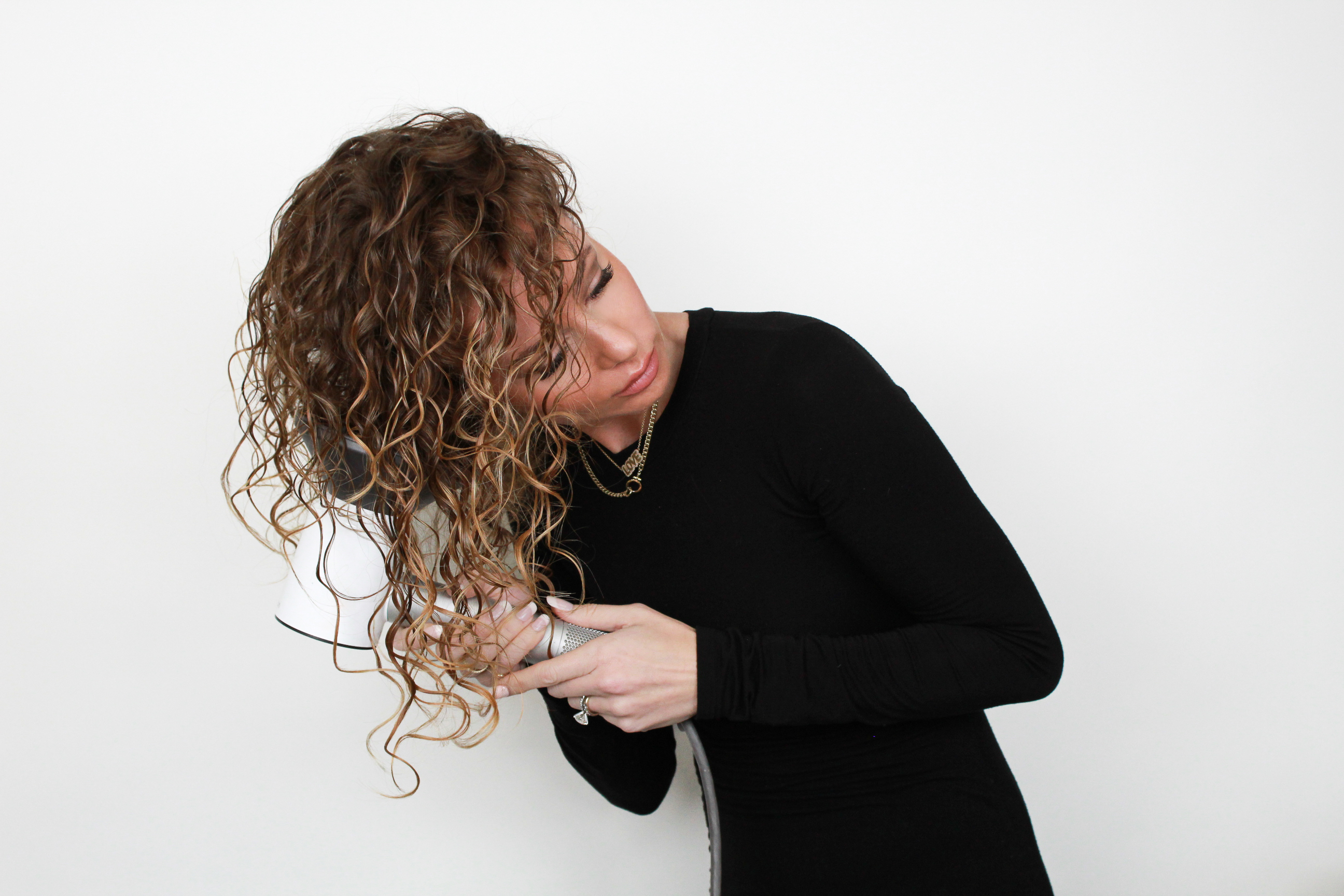 woman drying hair with diffuser attachment on blowdryer