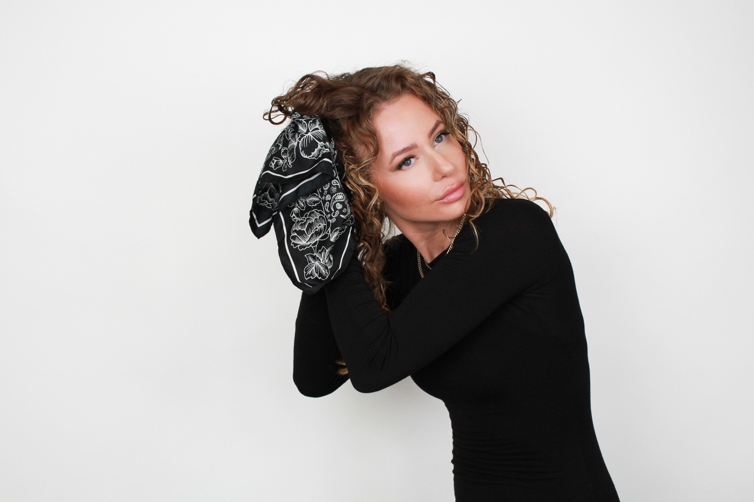 woman scrunching curls with a silk scarf