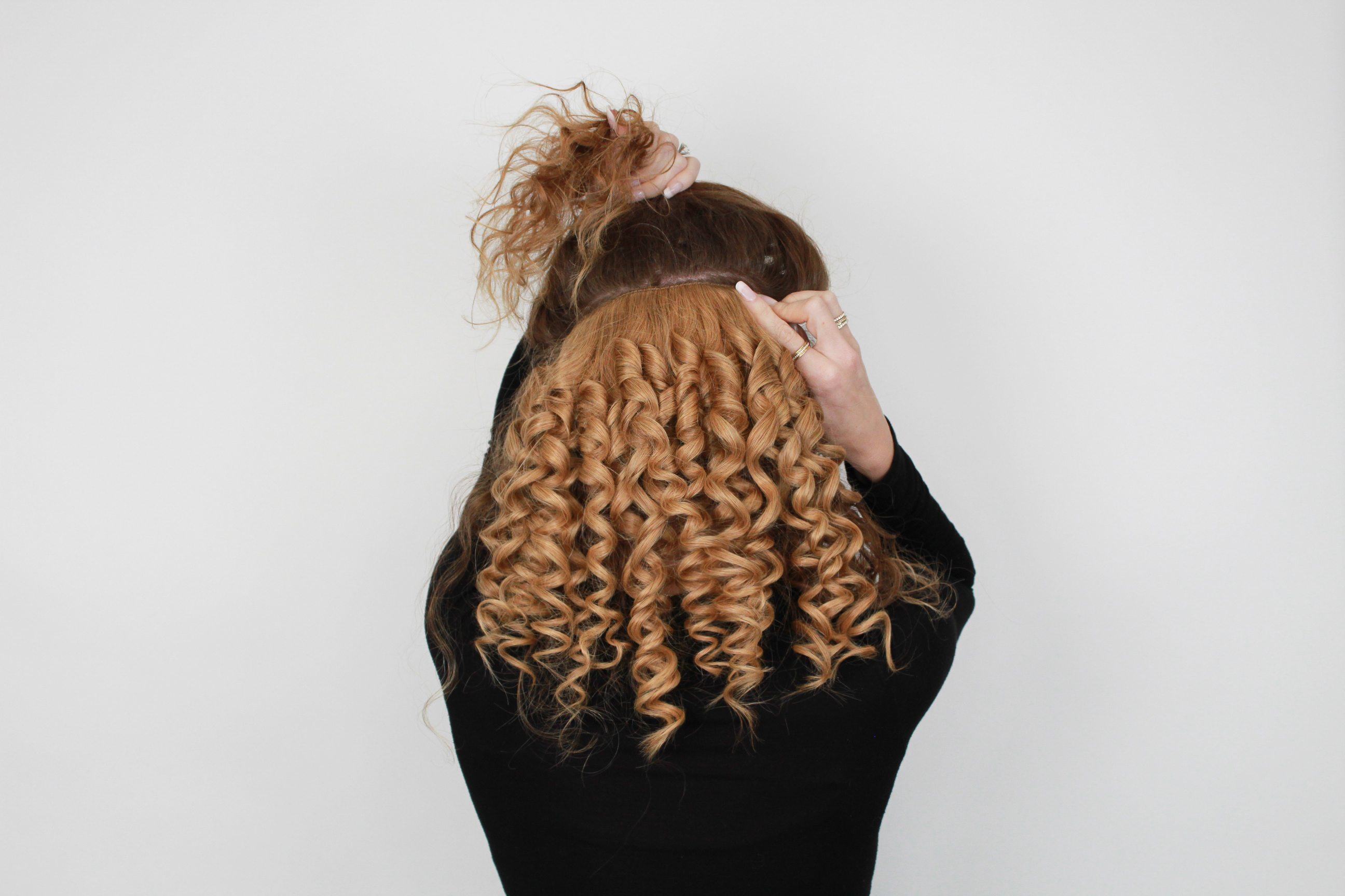 woman clipping in a curled volumizer one piece hair extension