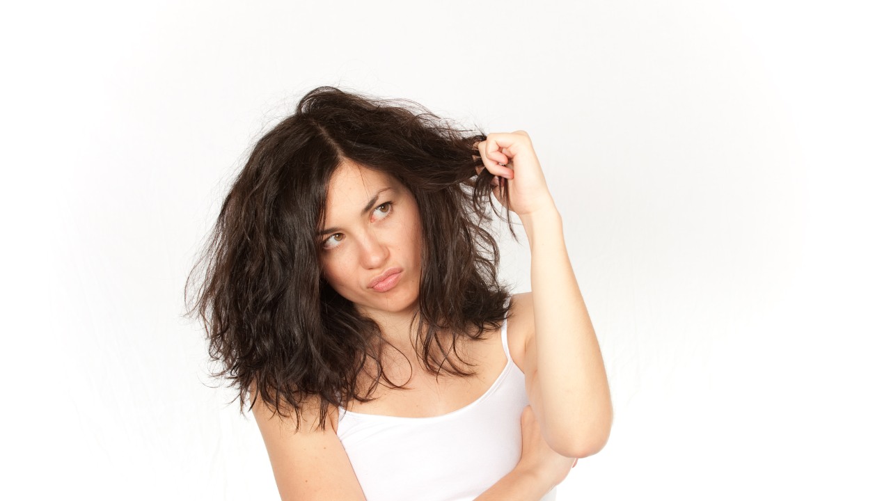 woman upset with her hair looking frizzy and tangled