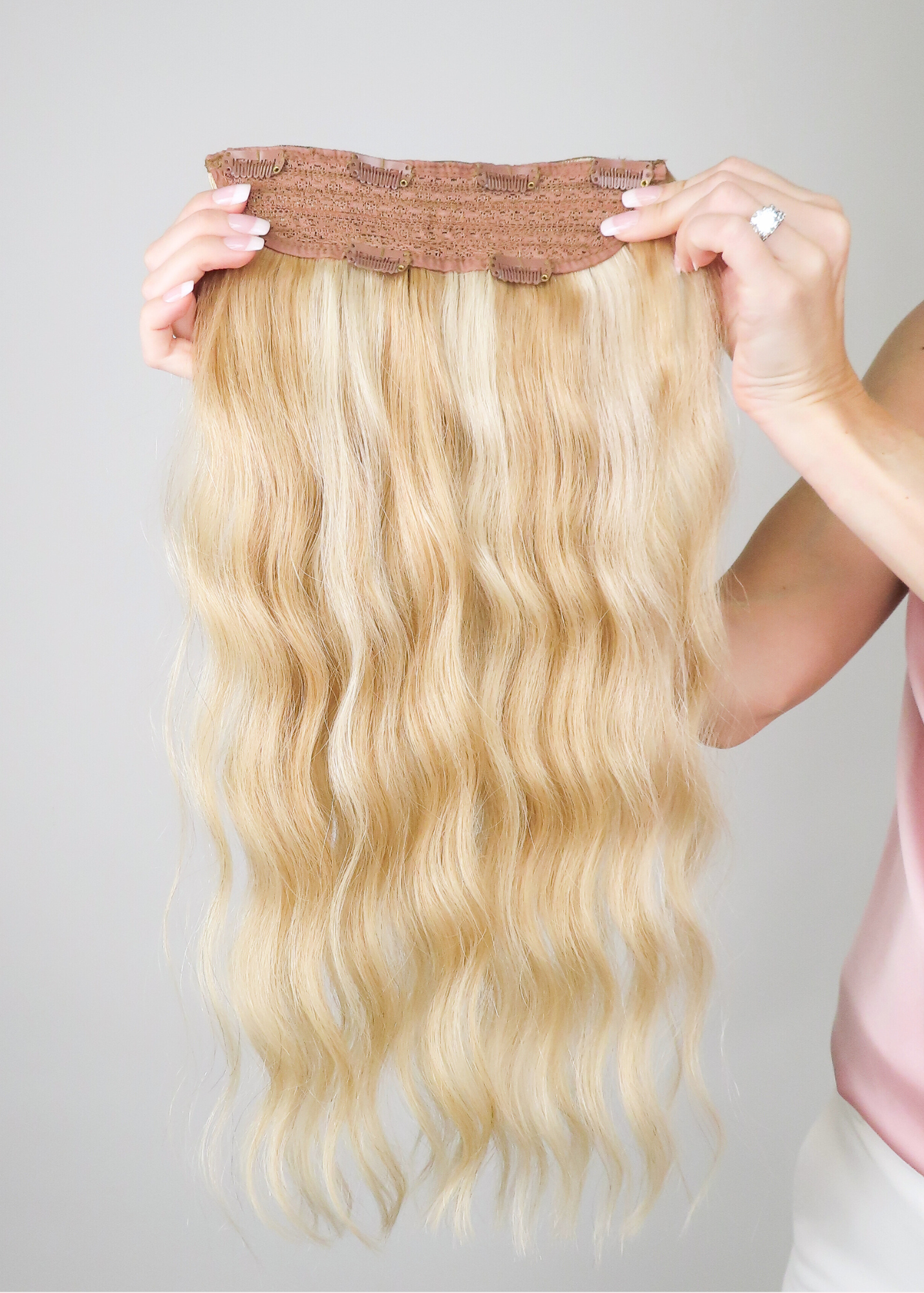 woman holding up the cashmere hair volumizer one piece extension